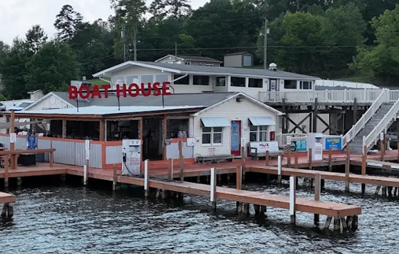 The Boat House on Lake Tillery waterfront building, red Boat House sign, docks, and fuel pumps viewed from the water