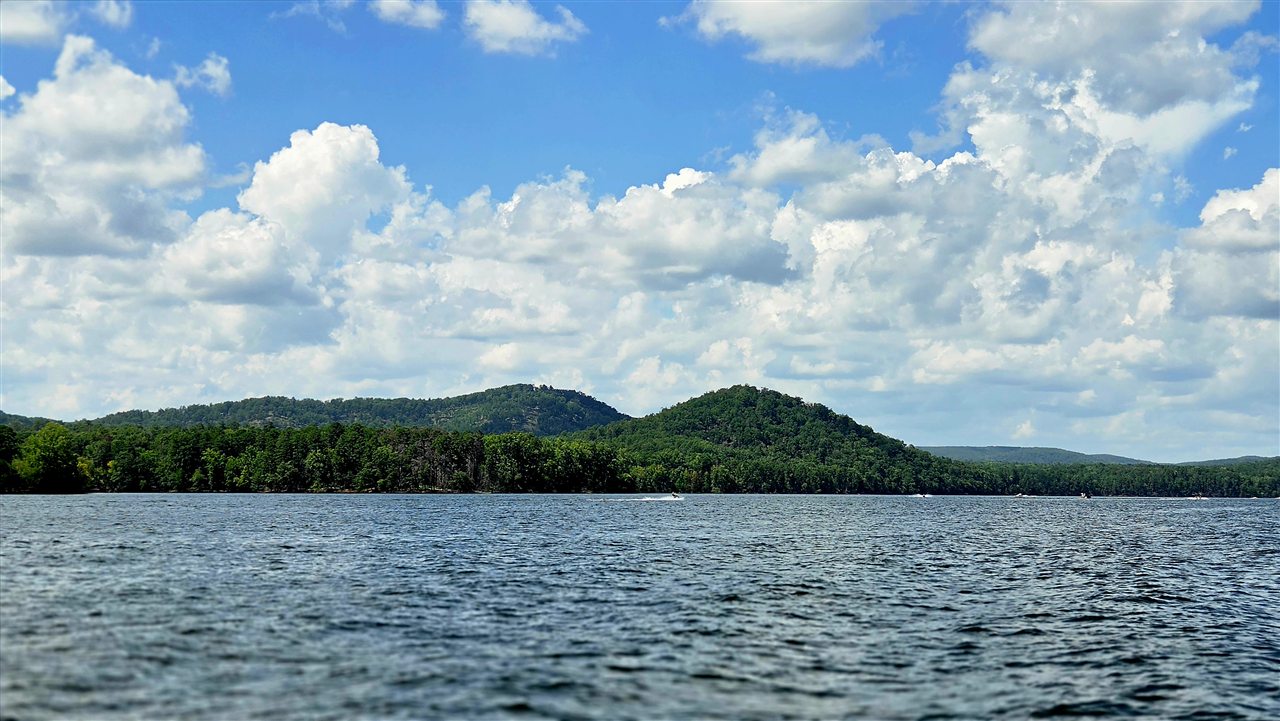 Open water on Lake Tillery with wooded hills under a summer sky